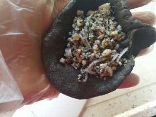 12、药膳美食之一一鸡屎藤糍粑,取一个粉团，压扁，放入大概25克左右馅料，象捏包子的方法一样捏好。