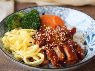 9、照烧鸡排饭,西蓝花、胡萝卜开水煮熟，码放在米饭上，鸡肉上淋汁，再撒熟芝麻