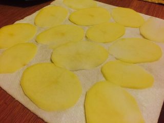 3、家庭健康薯片,把土豆放在厨房纸上 按压吸干多余水分。