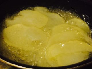 4、家庭健康薯片,锅中热油，油温5成热后放入土豆片。（五成热是木头筷子放入油中有细细的小泡。）全程小火炸制