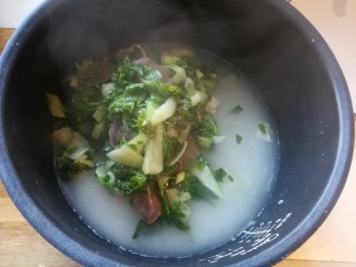 14、年味~腊肠青菜饭,把炒好的青菜腊肠倒在米上面。不用搅拌,因为米搅拌上来了以后容易夹生不熟。