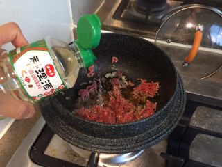 8、番茄茄丁肉酱拌面,热锅,倒油,烧热以后放入蒜末爆香,放入肉末,加一勺料理酒或者绍兴酒,快速滑开翻炒到全部变色。