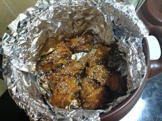 9、《健康美味的无烟烧烤 - 砂锅烤排骨》,把排骨翻身后，刷上烧烤酱和撒上白芝麻。然后盖上盖子继续烤。