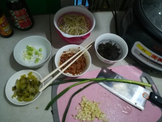 1、广式酸辣薯粉,猪肉加老抽生抽盐少量糖生粉腌一下，加几滴水拌一下一会儿容易炒松，豆芽我用黄豆比较有嚼劲，洗净，葱苗叶部分切段，葱白一部分切段一部分切丁，葱白切段的拍扁一下。木耳泡开切丝，酸菜切粒，蒜3瓣左右切碎，小米椒切碎，可以切葱花备用。