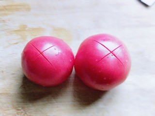 2、番茄炒蛋盖浇饭,首先将番茄洗干净，再顶端用刀划出十字刀。