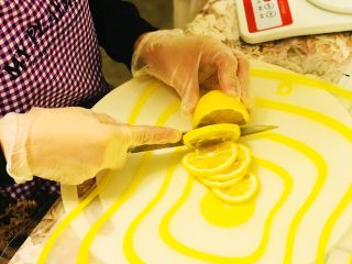 7、柠檬膏????,切成薄片，可以根据自己喜好薄厚适中就可以了，我是铺在下层的柠檬切的厚一点的。