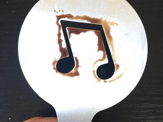 4、典典家私厨@五分钟早餐2,将音符铝片造型涂上巧克力酱,涂在烤好的吐司上。