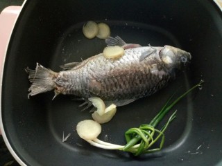 4、鲫鱼萝卜汤,一面煎好翻另一面煎，煎至两面金黄加少量料酒，放入葱段和生姜片！