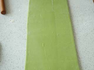 12、抹茶/原味蝴蝶酥,面片表面在撒一层面粉防粘，将其轻轻擀长，擀的时候用力要均匀，由中间往上下擀到20cm宽，将面片旋转90度，再由中间往上下擀到50cm。擀的时候，由中心向四角的方向擀，容易擀成规则的长方形(图中是配方双倍的量，所以面片擀的比较长)