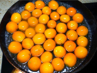 6、糖渍金桔,倒入金桔，盖上盖子煮沸后转小火焖煮。