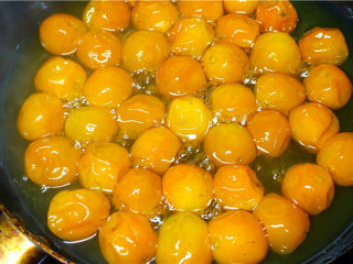 7、糖渍金桔,焖煮30到40分钟。直到出现半透明状态，此时的金桔皮会凹着贴着核，熄火盖上盖子让其浸泡6-8小时