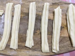 11、家庭版自制油条,把每两小段放一起,用一根筷子在面团中间压一下