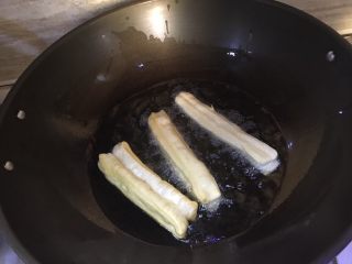 12、家庭版自制油条,锅内倒入足量的油,待油热后放入油条开始炸