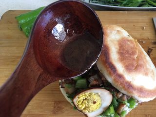 42、(Chinese Burger King)肉夹馍,在放半勺卤肉汤汁浇到肉中