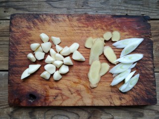 3、家庭版自制烤鱼,蒜去皮去蒂，蒜瓣大的一切二，小的不用切。葱姜切片备用。