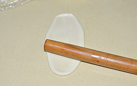 9、栗子酥,接下来,再将刚卷起来的面团收口朝下再次擀开成椭圆形。