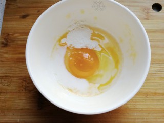 3、年夜菜~锦绣苔味香肠卷,鸡蛋一个打入碗中，加一点点牛奶和一勺淀粉搅拌均匀（两个鸡蛋分次进行，一个鸡蛋正好摊一张蛋饼）