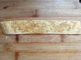 7、年夜菜~锦绣苔味香肠卷,取一条鸡蛋饼先抹上少许生蛋液（无需再打鸡蛋液，摊饼时碗上的残留蛋液就够用哈）