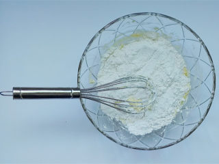 7、柚子蜂蜜迷你玛芬,把混合的低筋面粉倒入黄油糊里,翻拌均匀