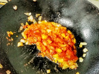 12、花样面条——蒜香排骨芝士意面(红酱时蔬版~),炒锅热油，放入剩下的蒜末，和一半的洋葱丁煸出香味儿，放入番茄丁，翻炒均匀至出汁，然后放入适量的番茄酱。