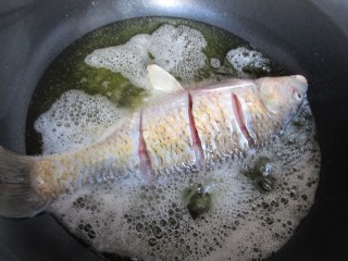 4、糖醋鲤鱼,油七成热时下入鲤鱼炸制。