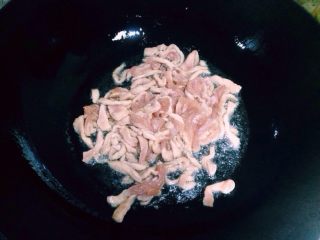 7、鱼香肉丝,把浆好的肉丝放入炒锅推散。