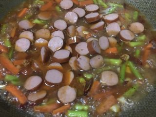 15、「吃货久久」足料拌日本拉面,我加入了黑椒汁 意面番茄汁 加入少许盐 连同熏肠一起倒入 不断翻炒 盐不必太多 毕竟熏肠是咸的 炒久点会出味