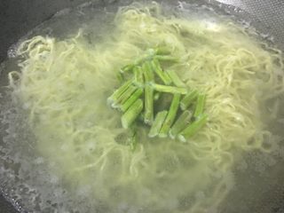 5、「吃货久久」招牌拌拉面,加水后马上加入芦笋一起煮熟
