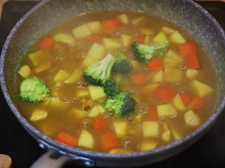 6、土豆红薯鸡胸咖喱,煮到筷子可以轻松扎透土豆的时候,加入西兰花,用锅铲帮助西兰花泡到汤里面~西兰花是非常容易熟的,基本上在汤里面泡着有个1-2分钟就可以了,所以西兰花加入之后就不需要再盖锅盖了。