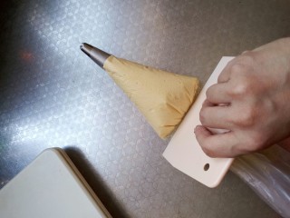 8、樱花????蛋黄小饼干,这里要用一个刮板将面糊推向花嘴 不要用手去推挤 这样手温会使蛋黄消泡