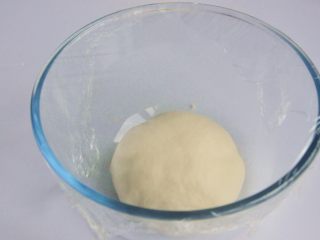 4、玉米沙拉三明治,将揉好的面团放入烤箱中进行第一次发酵，在面团上盖一层保鲜膜，烤箱里放一碗温水，30度1小时。