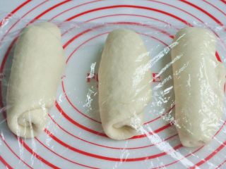 7、玉米沙拉三明治,将面团擀开卷成圆筒状，3个都做同样处理，盖上保鲜膜静置15分钟左右。