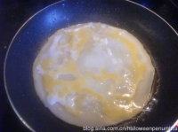 3、自制家庭版煎饼果子,打入一只鸡蛋。用锅铲把蛋黄戳破，划圈铺开