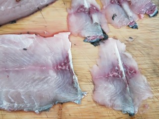 8、家常酸菜鱼,第二刀片到鱼皮，直接切断。如图所示。