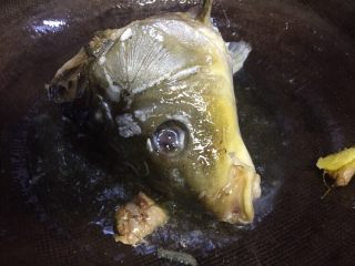 9、#菌类料理#白玉菇什锦鱼头汤,油温六成放入鱼头老姜煸炒，炒至鱼头变色