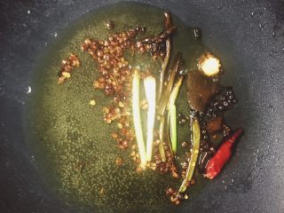 7、口水鸡,炸好的花生盛出备用，锅里再放一根切段的葱，一把花椒，2个大料，一片香叶，小火慢炸（我的为了拍个照，不小心炸糊了！大家不要学我啊）