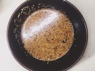 8、口水鸡,油稍微放一下，不太热时候，辣椒碗上放小筛网，把熬好的油过筛进去。这里注意，油太热，辣椒粉会糊，太凉辣椒粉会生炸不出辣椒香。如果不敢保证油温，可以先过滤出香料，用勺子舀一勺看看状态，如果觉得油温不热再继续加热下油，油温太热就再放一下。