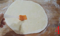 4、葱油饼,取一个面剂，揉匀，擀成圆饼，将调好的油糊刷在饼上