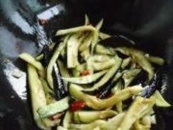 5、鱼香茄子,5.腌制过的茄子挤出水分，倒入锅中，加入红辣椒翻炒均匀。