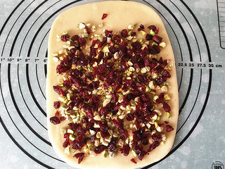 8、果仁大列巴,将33克/开心果、40克/蔓越莓均匀铺在上面，上端留少许不放