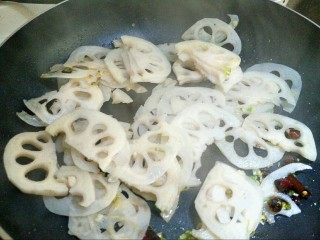 9、炝炒莲藕,把莲藕从水里捞出来,加入锅里。大火快炒1分钟。