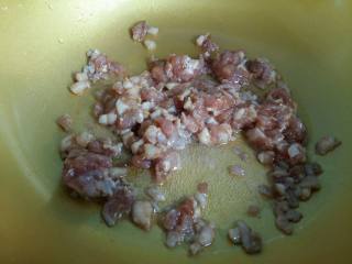 9、#绿色美食#五色蔬菜炸酱面,热锅凉油，倒入适量菜籽油，把腌制好的肉丁倒进去中小火翻炒。