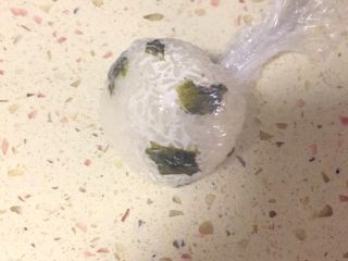 10、足球饭团,包好用力的压一下成一个圆形，一个简单的足球饭团就做好了。