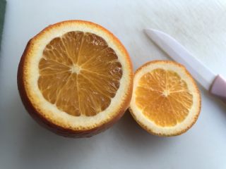 3、盐蒸橙子(止咳功效),用小刀切去橙子一部分,露出橙子肉。