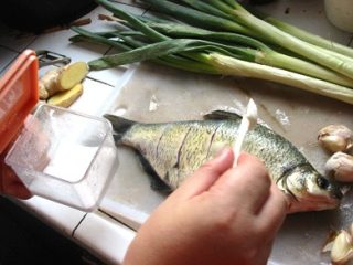 5、红烧鳊鱼,在鱼的两侧均匀抹上一些盐,甚至腹腔内也可以弄一点,稍微做点前期的入味!