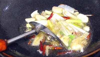 7、红烧鳊鱼,下锅油烧冒蓝烟后,下入配料煸香,火不能太大,主要是炒出香味.