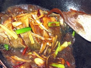 12、红烧鳊鱼,放入先前的配料一起烧,汤中放入少许盐,要考虑量哦,因为酱油也是咸的,后面还要加酱,包括鱼本身以及入过味了!不停的把汁浇在鱼上,保证均匀受热!