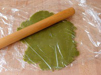 9、小清新抹茶饼干,烤箱预热到150℃，拿出面团，用两片保鲜膜包住它，然后将它擀扁