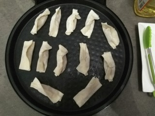 11、家庭版自制锅贴,将锅贴平铺在饼铛中，开火慢慢煎制。