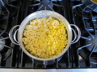 4、芝士通心粉,加入RICOS浓缩车打芝士酱，搅拌均匀，然后倒入酸奶，搅拌均匀。将煮熟的通心粉捞出，倒入酱汁中，确保所有的面和酱均匀。